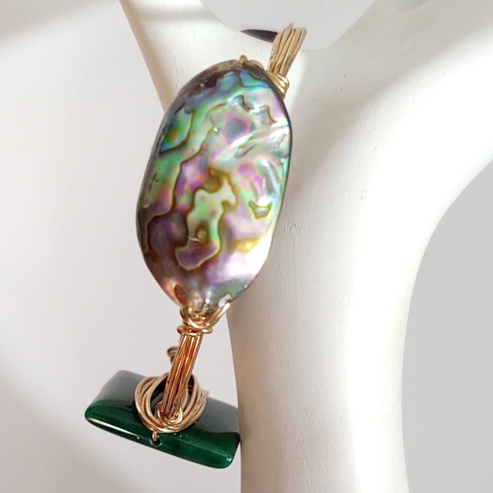 Gold wire wrapped abalone shell, green stone and purple bead bangle